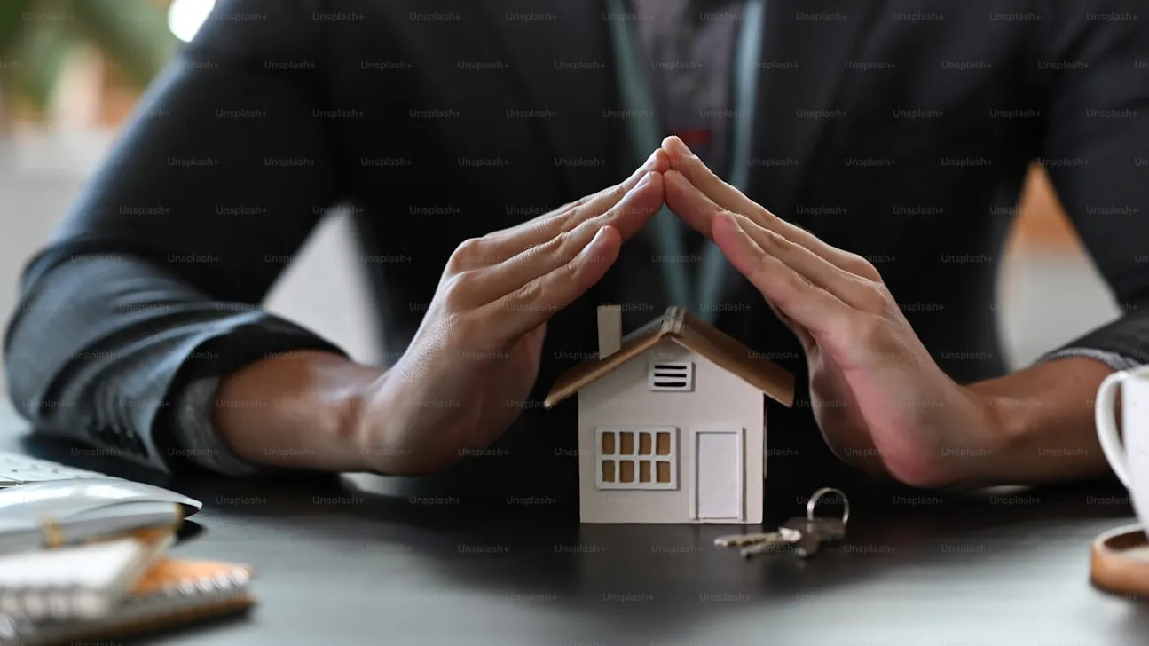 Hands sheltering a model home